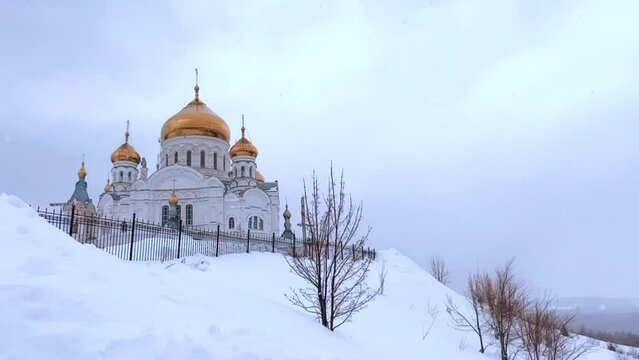 Belogorsky St. Nicholas Orthodox Missionary Monastery. Russia, Perm Krai, Belaya Gora. The temple on the hill in winter. Monastery on the background of snow. 4K