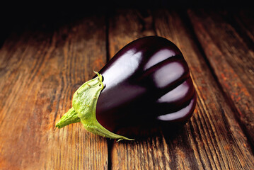 Eggplant on wooden background, fresh juicy vegetable on wooden rustic background,  soft focus