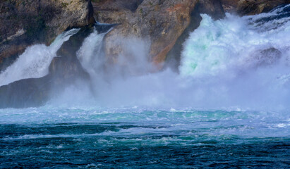 water from the waterfall flows from the stones into the river