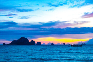 Tropical paradise sunset turquoise water beach limestone rocks Krabi Thailand.