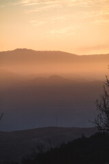 Sunrise over the hills with vibrant orange tone.