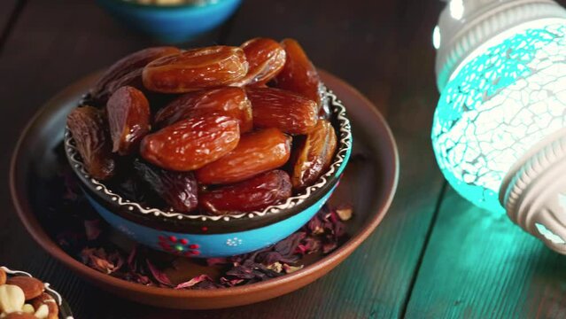 Bowl with dried dates, nuts and milk on a wooden boards. Ramadan Kareem and iftar muslim food. Panning camera shot