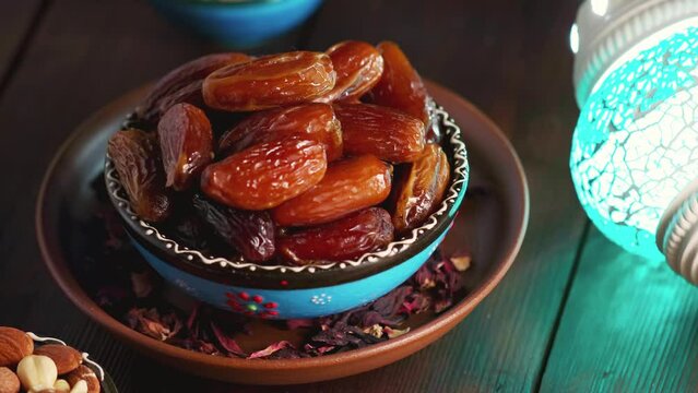 Bowl with dried dates, nuts and milk on a wooden boards. Ramadan Kareem and iftar muslim food. Panning camera shot