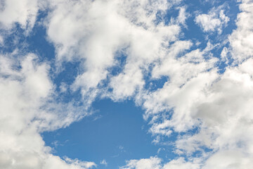 Beautiful blue sky with large white clouds backdrop. April weather spring sky background