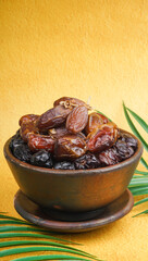 Various type of dried dates fruits on yellow background