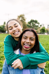 Vertical portrait of two diverse multiracial smiling best friends. Female friendship concept