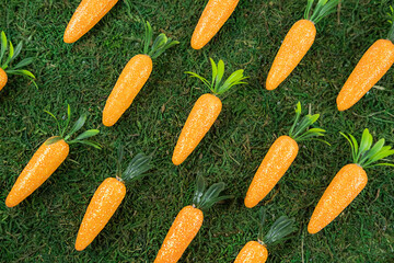 Easter pattern background made of decorative carrots on natural organic texture,