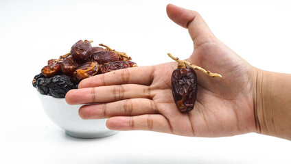 hand pick a dried date fruit from a bowl