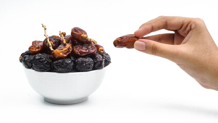 hand pick a dried date fruit from a bowl