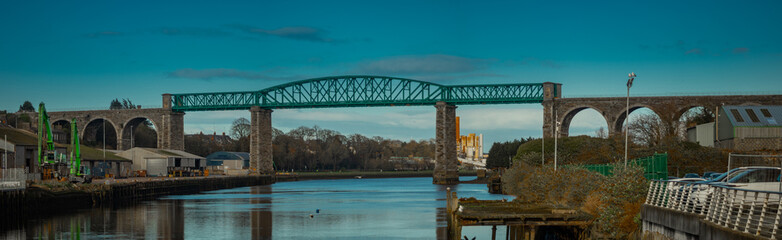 Obraz premium Amazing Boyne viaduct in drogheda spanning over river Boyne in early evening hours. Beautiful pucture of a green metal viaduct and stone arches.