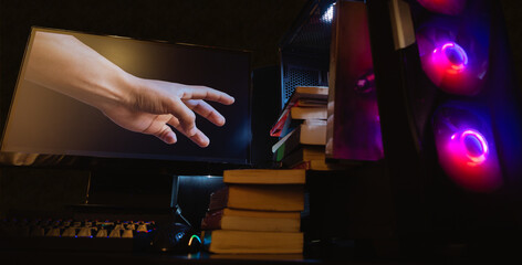 MANOS AGARRANDO LIBROS DENTRO DE UNA COMPUTADORA EN FONDO NEGRO, CONCEPTO DE TECNOLOGÍA Y...