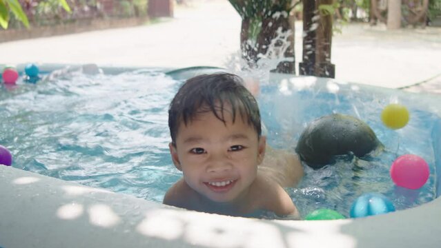 Boy playing in a small pool, summer