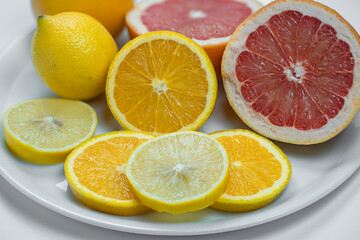 Fototapeta na wymiar Slices of lemon, grapefruit and orange assorted on a plate