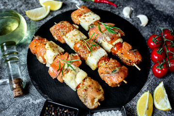 raw salmon skewers on skewers on a stone background.Raw seafood on skewers