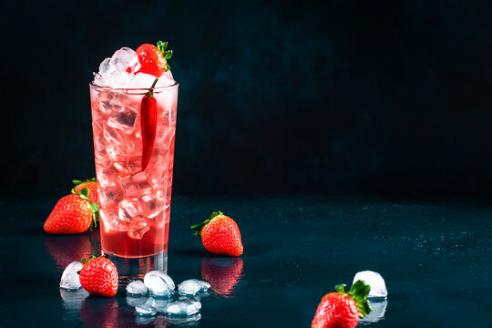 Oldboy alcoholic cocktail drink with vodka, grapefruit juice, strawberries, sugar, cinnamon and hot chili pepper. Highball glass on dark blue background