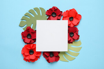 Blank paper sheet with poppy flowers and palm leaves on blue background