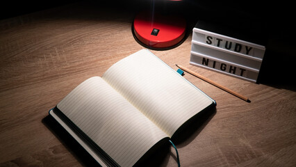 Study concept background. Notepad with blank pages and desk lamp on wooden table high angle view....