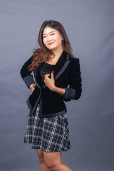 beautiful chinese asian women dressed in formal office wear jackets and skirts. the girl's expression smiled thinly in a formal pose, all her hands were holding a jacket and her body was tilted