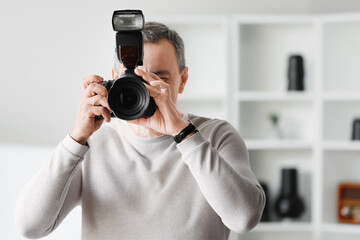 Fototapeta premium Mature photographer with professional camera in studio, closeup