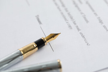 Fototapeta premium Fountain pen on paper document, closeup. Notary services