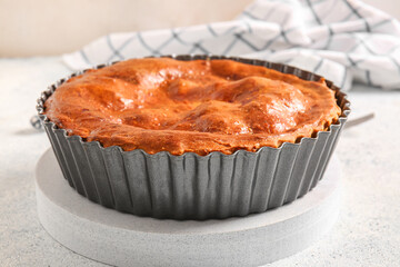 Delicious meat pie in baking form on white grunge table