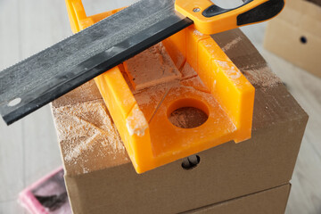 Saw and miter box for decorative brick installation indoors, closeup