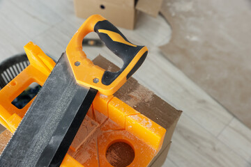 Saw and miter box for decorative brick installation indoors, closeup