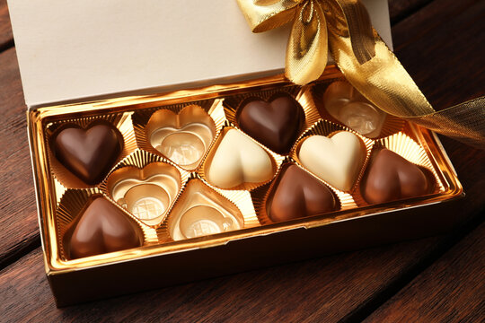 Partially empty box of chocolate candies on wooden table