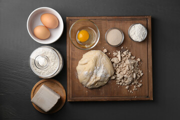 Different types of yeast, eggs, flour and dough on grey wooden table, flat lay