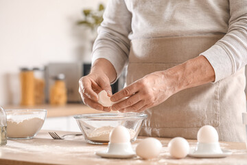 Obraz na płótnie Canvas Male chef making dough for pasta at table in kitchen, closeup