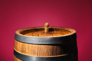 Wooden barrel on pink background, closeup