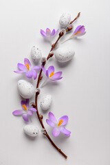 Composition with willow branch, Easter eggs and beautiful crocus flowers on light background