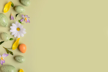 Composition with Easter eggs and spring flowers on green background