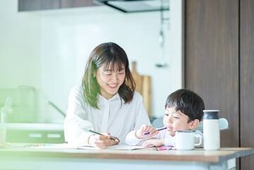 Obraz na płótnie Canvas 部屋で鉛筆とノートを使って勉強する親子