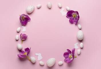 Fototapeta na wymiar Frame made of Easter eggs, tulips and paper rabbits on pink background