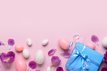 Easter eggs with gift and tulips on pink background