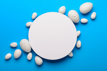 Composition with blank greeting card and Easter eggs on blue background