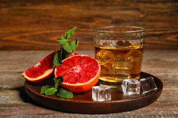 Glass of rum with ice, mint and Sicilian orange on table