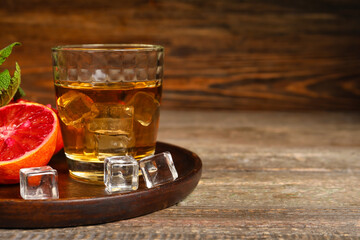Glass of rum with ice and Sicilian orange on table
