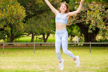 公園で楽しそうにジャンプするオーストラリアの女の子