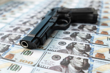 black gun on the background of cash dollars. concept of criminal money or murder for money. bank...