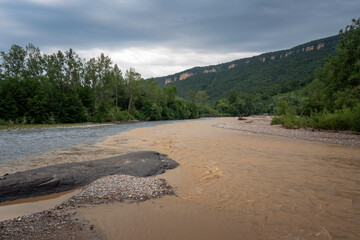 The confluence of the Belaya and Dakh Rivers and the Una-koz ridge of the Caucasus Mountains in the background on a sunny summer day with clouds, Dakhovskaya, Republic of Adygea, Russia