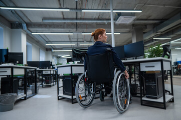 Obraz premium Caucasian woman in wheelchair at work desk.
