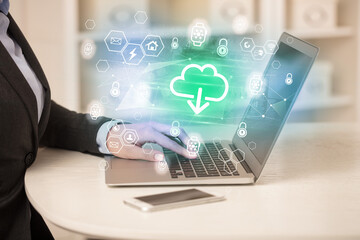 Hands working on laptop with digital icons