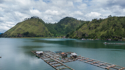 Aerial view of Lake Laut Tawar surrounded by green mountains.