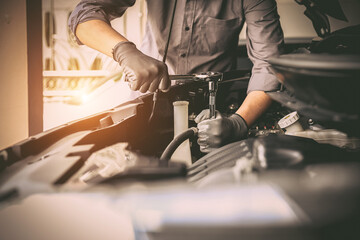 Close-up hand auto mechanic using the wrench to repairing car engine problem. Concepts of check and fix car and maintenance servicing.