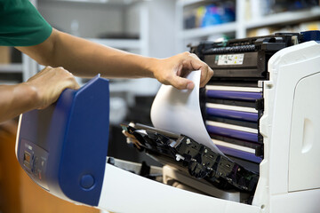 Technician hand open cover photocopier or photocopy to fix repair copier paper jam and replace ink...