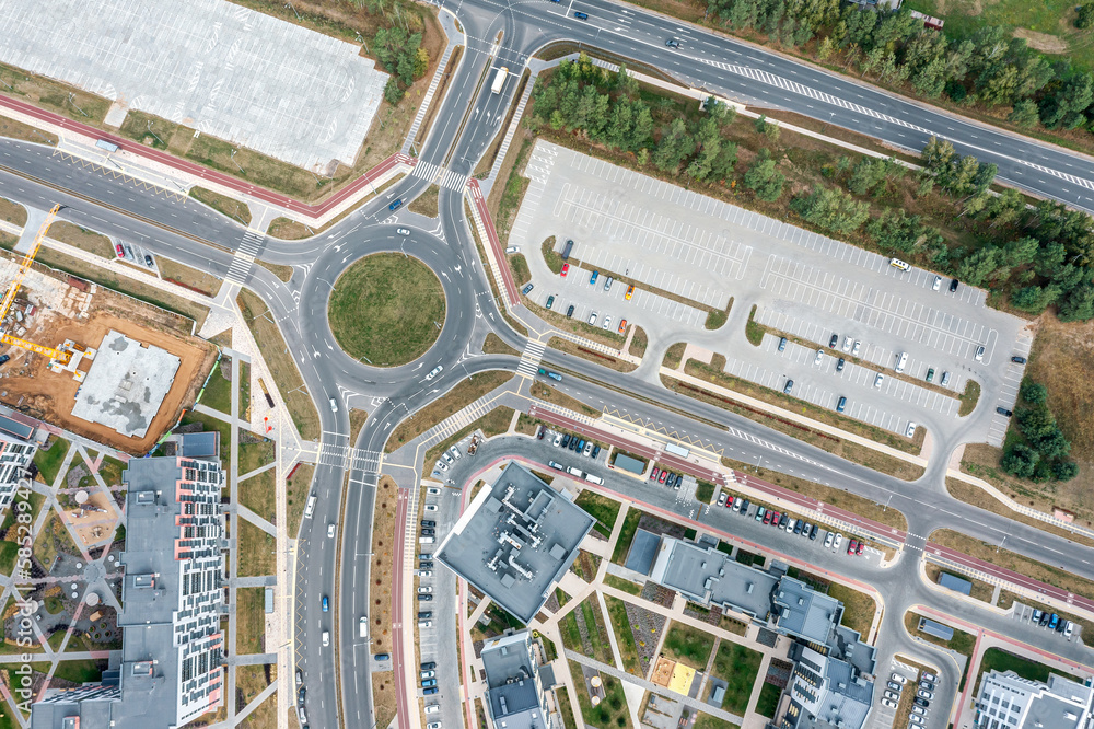 Wall mural roundabout circular intersection road and parking lots in city residential area. aerial top view.