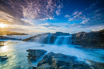 Waterfall at the rocky beach