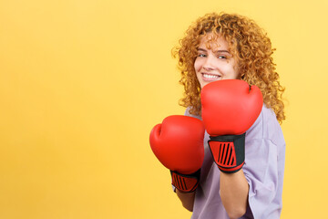 Cool woman using boxing gloves while smiling at the camera